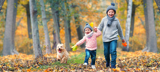 zwei lachende Kinder im Herbst im Park