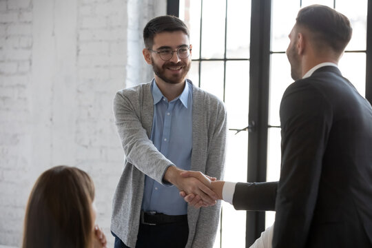 Businessman shake hand greeting get acquainted with smiling male employer at meeting, business partners handshake closing deal at briefing, make agreement at office negotiation, acquaintance concept