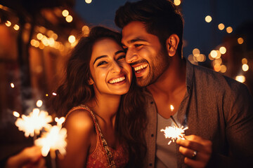 Obraz na płótnie Canvas Couple holding burning sparklers in hand and celebrating diwali festival.
