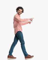 side view of happy curly hair man smiling and pointing fingers