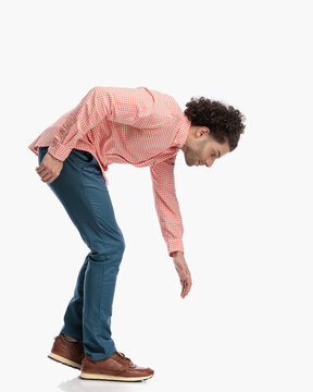 side view of casual man leaning forward while walking and looking down