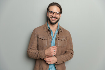 happy casual man wearing brown leather jacket and adjusting sleeves