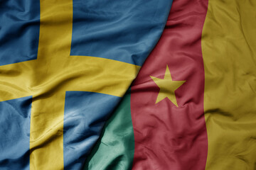 big waving national colorful flag of sweden and national flag of cameroon .