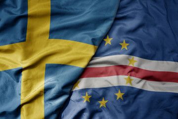 big waving national colorful flag of sweden and national flag of cape verde .