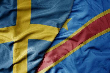 big waving national colorful flag of sweden and national flag of democratic republic of the congo .