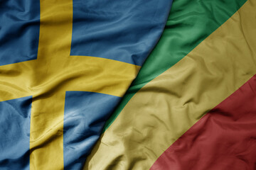 big waving national colorful flag of sweden and national flag of republic of the congo .