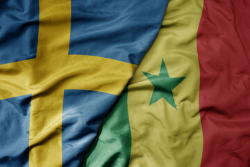 big waving national colorful flag of sweden and national flag of senegal .