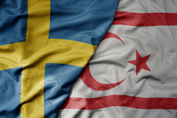 big waving national colorful flag of sweden and national flag of northern cyprus .
