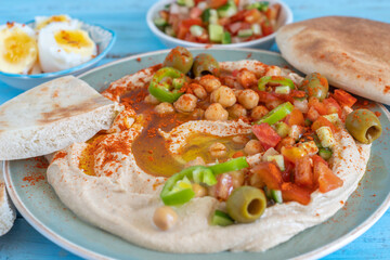 Chickpeas, pita bread on hummus plate. Israeli style hummus serving.