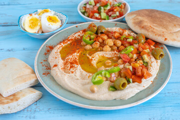 Chickpeas, pita bread on hummus plate. Israeli style hummus serving.