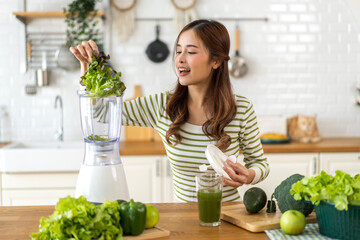 Portrait of beauty healthy asian woman making green vegetables detox cleanse and green fruit smoothie with blender.young girl drinking glass of smoothie, fiber, chlorophyll in kitchen.Diet, healthy