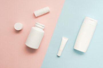 Flat lay of cosmetic bottles and tubes on two colored background