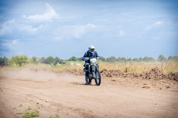 Enduro bike racer driving on dirt motocross dust track