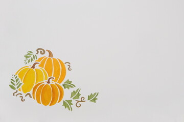 Three Orange Watercolor Pumpkins with Green Leaves in Lower Left Corner on White with Room for Text