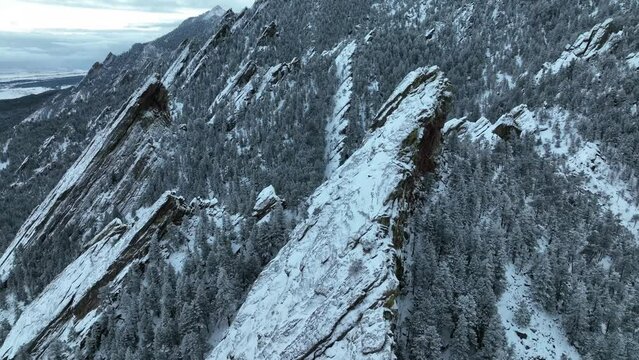 Drone video of Flatirons near Boulder, Colorado. Large flat rock formations along front range mountains on snowy day.