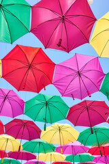 Fototapeta na wymiar Hanging colorful umbrellas against the blue sky.
