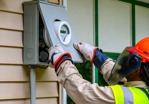 An electrical technician removes the old Power Meter and replaces it with a new Smart Meter at our home in Windsor in Upstate NY.  PPE worn at all times by Worker.