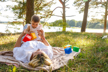 baby girl playing with mom in the park