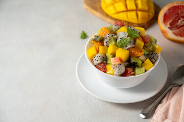 Exotic fruit salad with fresh mango, dragon fruit, grapefruit, kiwi. Copy space