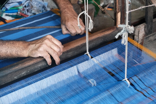 Weaver weaving traditional lungi by handloom at Joypara, a village in Bangladesh