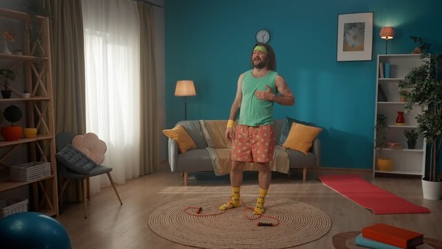 A middle-aged man with long hair. Standing on the floor in the room holding his heart at his feet is a jump rope that he threw away. He stares off into the distance showing the pain in his chest