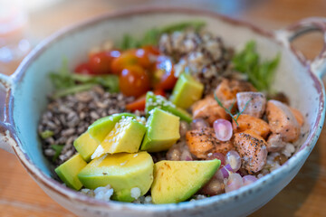 Mixed salad with grilled salmon meat on wooden table for lunch.