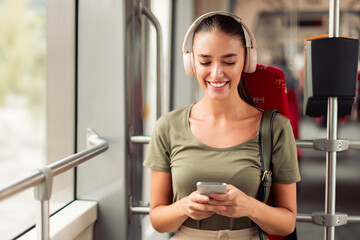Lady Using Cellphone And Listens Music While Sitting In Tram