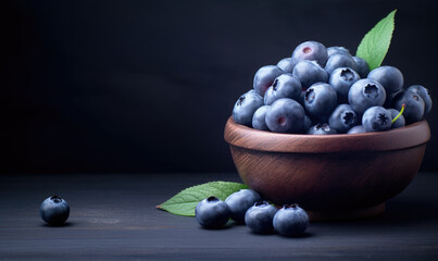 Fresh blueberries in a wooden bowl on a dark, rustic table