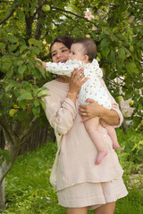 sanctuary of her verdant backyard, a young mother holds her infant, teaching her the beauty of connecting with nature early on. Eco-Conscious Parenting: Raising the Next Generation