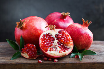 Delve into Pomegranate Delight. Side view photo of ripe pomegranate fruit slices seeds and green...