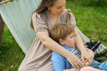 tender moment unfolds as a loving mother and her 5-year-old son engage in heartwarming dialogue, all while nestled in a hammock on a balmy summer day