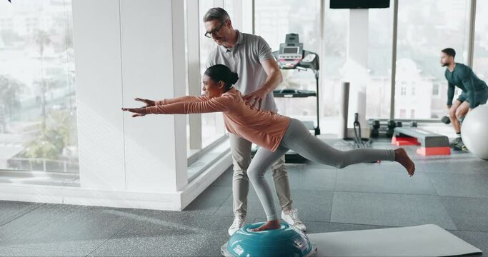 Coach, balance ball and woman training for health, wellness and fitness with advice from professional. Gym, physical therapy and athlete with physiotherapist for workout rehabilitation and support