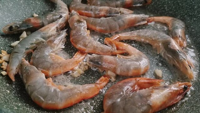 fresh, tiger prawns, frying in a frying pan, fried in oil with garlic and spices, mobile video,