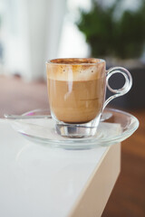 Texture of Capuccino coffee on a white table. Front view