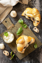 Croissant with cream cheese and mushroom on a stone background. French pastry, tasty freshly baked sandwich. Vegan food style. View from above.