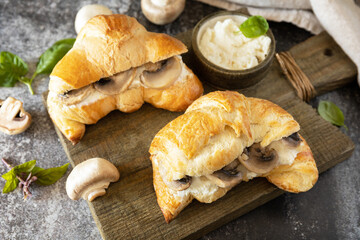 Croissant with cream cheese and mushroom on a stone background. French pastry, tasty freshly baked sandwich. Vegan food style.