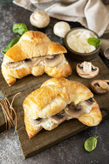 French pastry, tasty freshly baked sandwich. Vegan food style. Croissant with cream cheese and mushroom on a stone background.