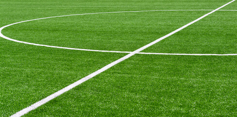 Obraz premium Green synthetic grass sports field with white line shot from above. Soccer, hurling, lacrosse, rugby, football, baseball sport concept