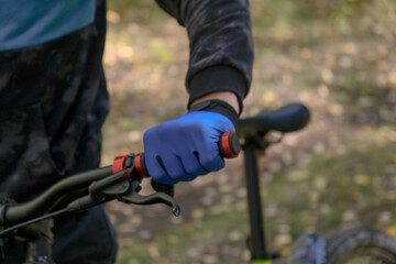 Cyclist's hand in a blue glove close up.Cycling.Hand on the handlebars of a bicycle