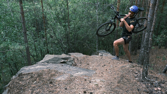 cyclist in a protective helmet carries a bicycle in a mountainous area.Active lifestyle