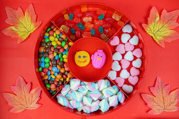 Set of different tasty candies in a red candy box on red background. variety of sweets and candies