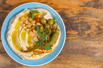 Hummus plate on wooden background with copy space.