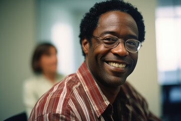 Obraz premium studious middleaged Afro American man, warm smile mirroring patience, displays remarkable eficacy with exposure therapy. In serene, private clinic, he carefully guides young client through
