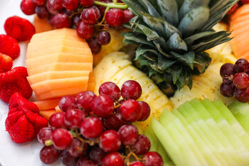 fruits, tomatoes, cheese, and charcuterie on a platter, symbolizing a delectable and balanced culinary experience