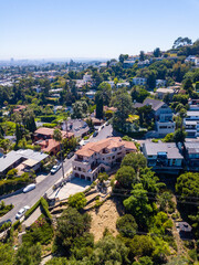 Fototapeta premium Aerial view of the Los Feliz neighborhood with large houses in the hills and downtown Los angeles skyline in the background.