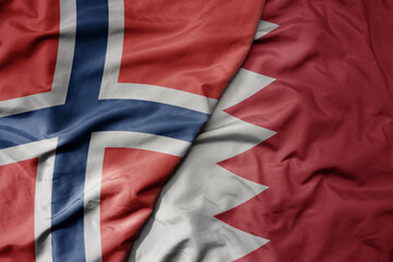 big waving national colorful flag of norway and national flag of bahrain .