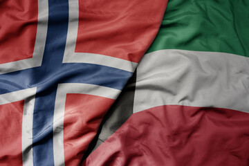 big waving national colorful flag of norway and national flag of kuwait .