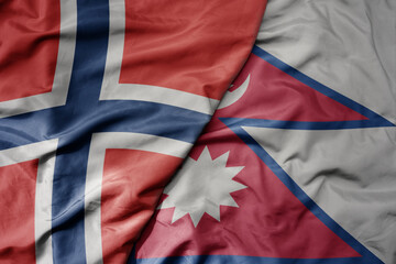 big waving national colorful flag of norway and national flag of nepal .
