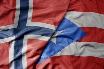 big waving national colorful flag of norway and national flag of puerto rico .
