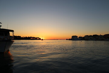 Sunset with boat silhouettes on the Adriatic sea in Porec, Istria, Croatia, Europe. Beautiful...
